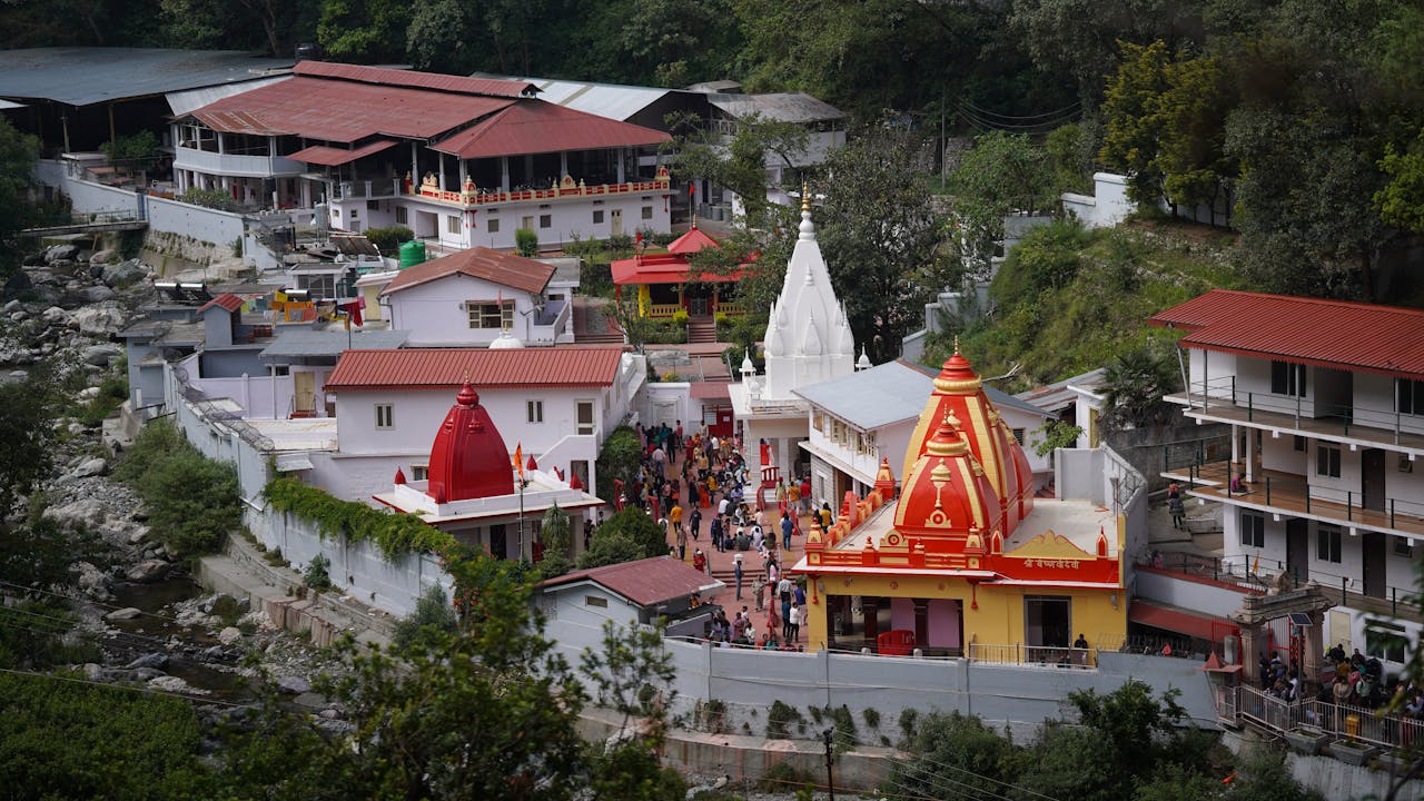 services-03 A vibrant aerial shot of the famous Kainchi Dham Temple complex surrounded by lush greenery in Uttarakhand.